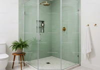 Modern green tiled shower with gold fixtures and plant