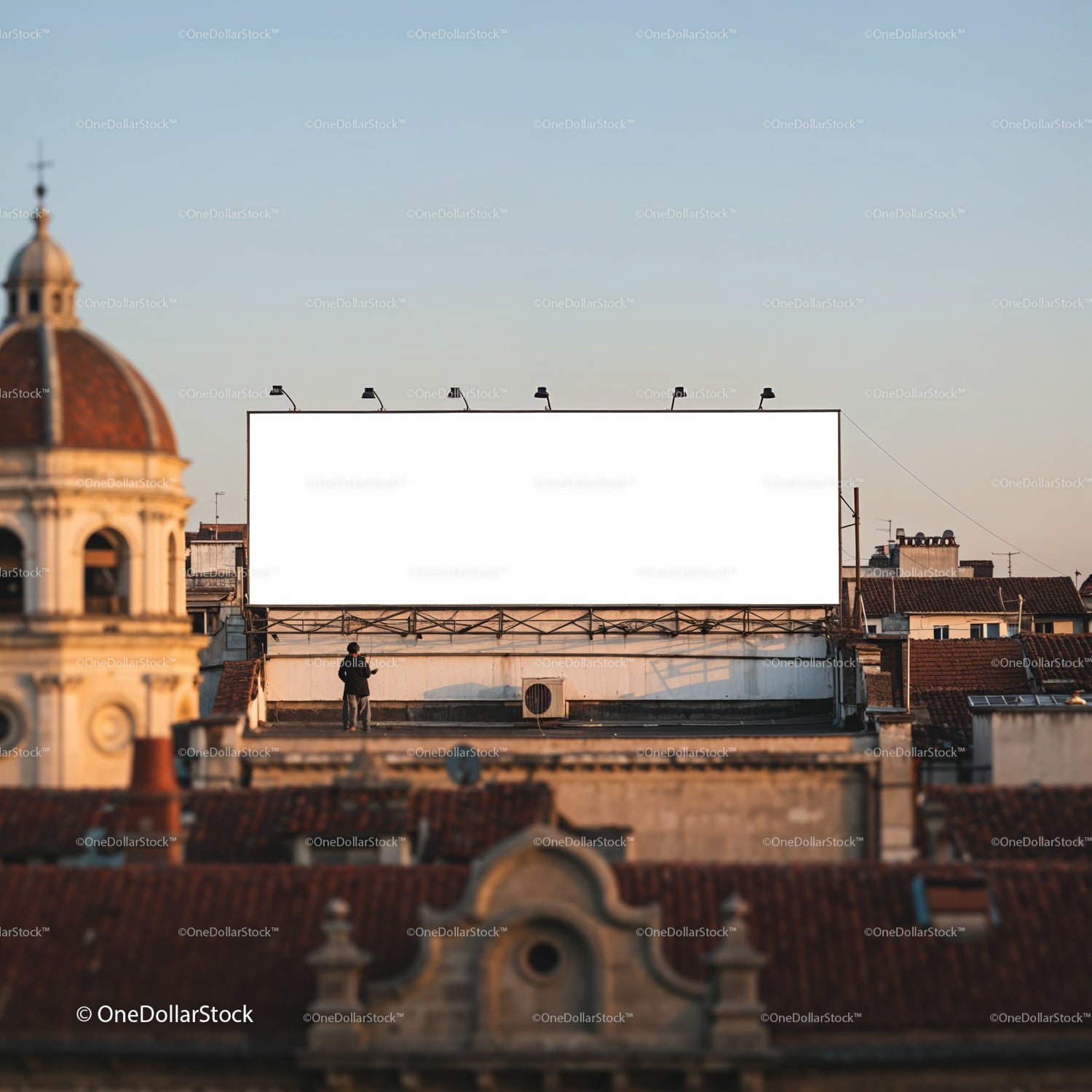 Mężczyzna stojący w pobliżu dużego, pustego billboardu nad dachami miasta