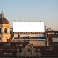 Man Standing Near Large Blank Billboard Over City Rooftops