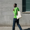 Stylish Woman in Green Sweater Carrying Tote Bag in Urban Setting