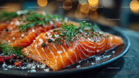 Fresh Sliced Smoked Salmon with Herbs and Sea Salt on Black Plate