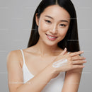 Beautiful Young Woman Applying Skincare Cream on Hand