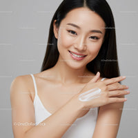 Beautiful Young Woman Applying Skincare Cream on Hand