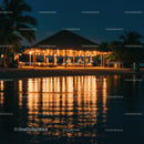 Tiki Hut by the Beach at Night with Warm Lighting and Reflection
