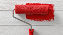 Red Paint and Roller on White Wooden Surface for Interior Wall Design