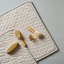 Natural baby grooming brushes and pacifier on mat