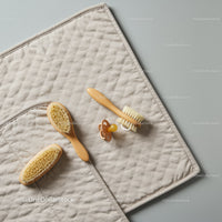Natural baby grooming brushes and pacifier on mat