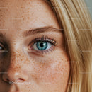 Close-up of blue eye and freckled skin on blonde woman