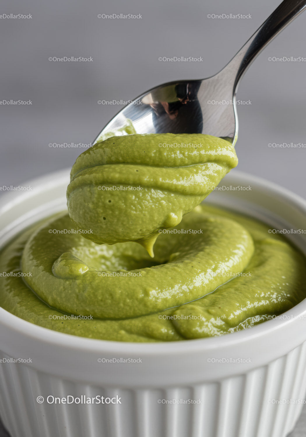 Creamy green avocado dip in white ramekin with spoon