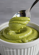 Creamy green avocado dip in white ramekin with spoon
