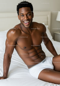 Smiling muscular man relaxing on bed in white underwear