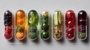Assorted Capsule Containers with Vitamins and Supplements in a Row