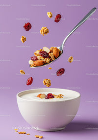 Spoon with granola and nuts over bowl of yogurt