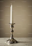 Silver candlestick with white candle on marble table in elegant home setting