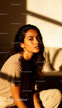 Woman bathed in warm sunlight with thoughtful expression