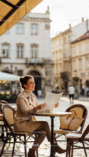 Smiling woman exploring city with map at outdoor café