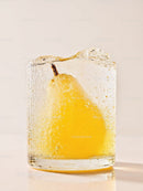 Fresh yellow pear frozen inside a clear ice block