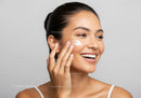 Young Woman Applying Face Moisturizer for Healthy Glowing Skin