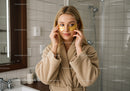 Relaxing Woman Applying Gold Under Eye Patches in Spa