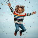Joyful child jumping surrounded by colorful confetti