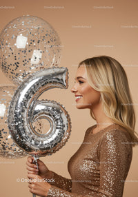 Smiling woman celebrating with silver number six balloon