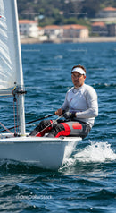 Man Sailing a Small Yacht in Blue Ocean Water