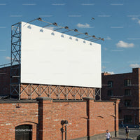 Large blank billboard mounted on brick building under blue sky