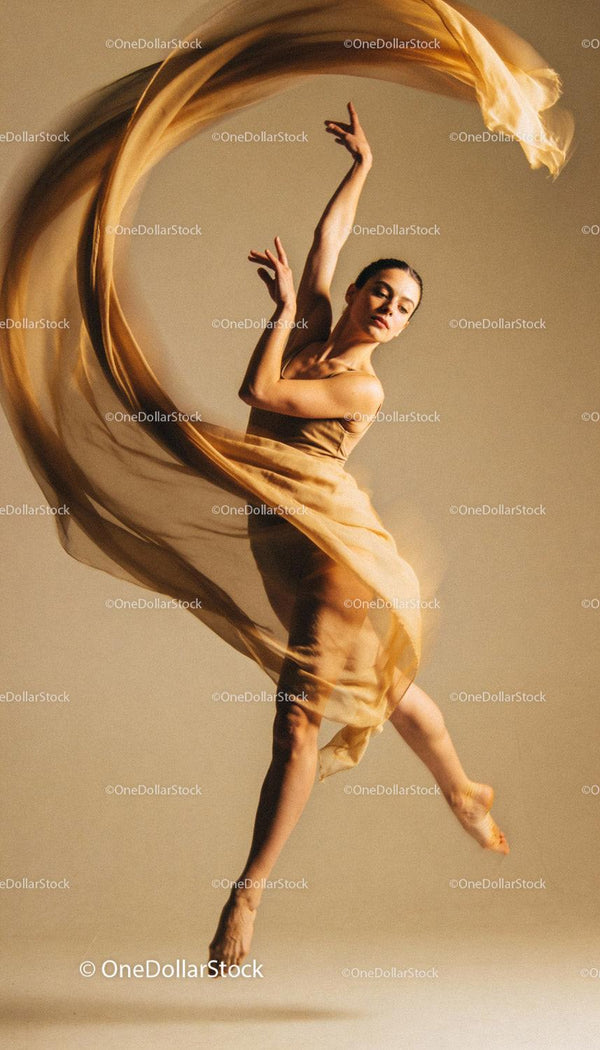 Graceful female dancer leaping with flowing fabric