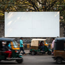 Busy street with auto rickshaws passing by urban wall