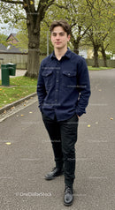 Young man standing confidently on a leafy suburban street