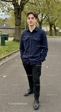 Young man standing confidently on a leafy suburban street