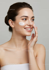 Young Woman Applying Moisturizer with a Bright Smile