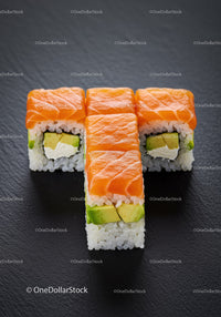 Fresh Salmon Avocado Sushi Rolls on Black Surface