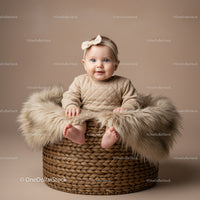 Smiling baby girl sitting in cozy woven basket