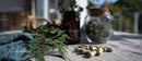 Herbal Leaves and Medicine Capsules with Glass Jars in Natural Lighting