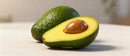 Fresh ripe avocado with seed on light surface