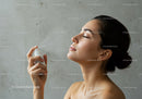 Woman with Flawless Skin Applying Facial Mist for Refreshing Hydration