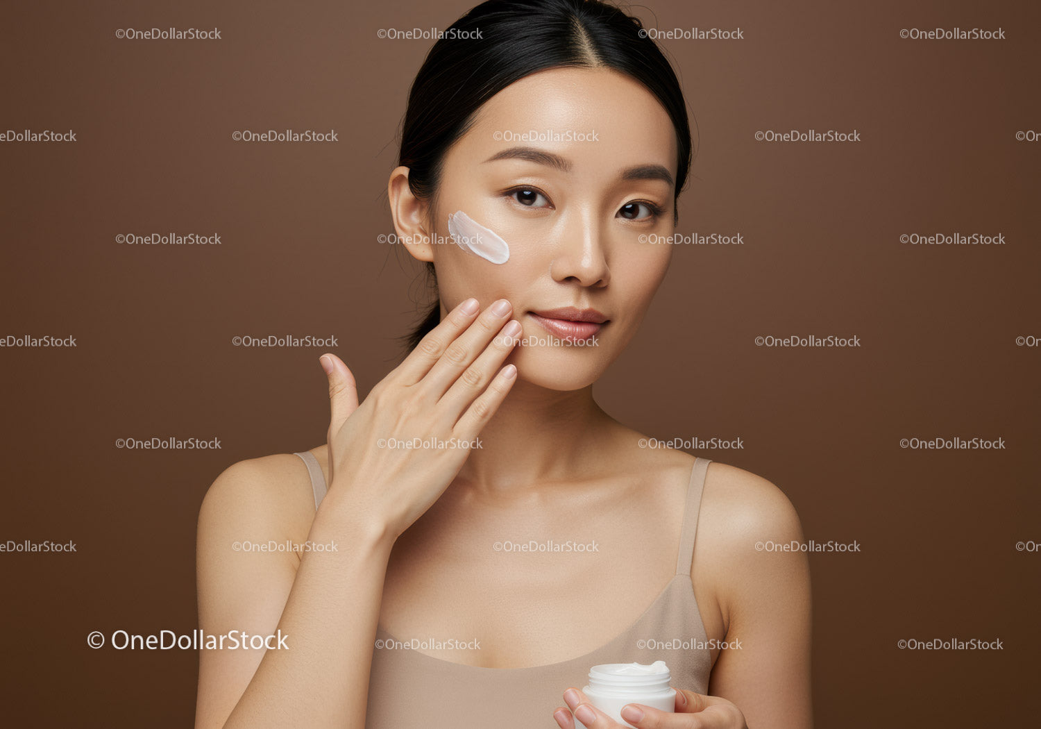 Young Woman Applying Skincare Cream with Calm Facial Expression