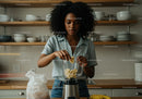 Black woman preparing healthy banana smoothie in modern kitchen