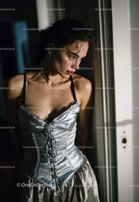 Elegant Woman in Satin Corset Looking Thoughtfully by Window
