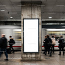Urban commuters passing a blank ad panel in subway station