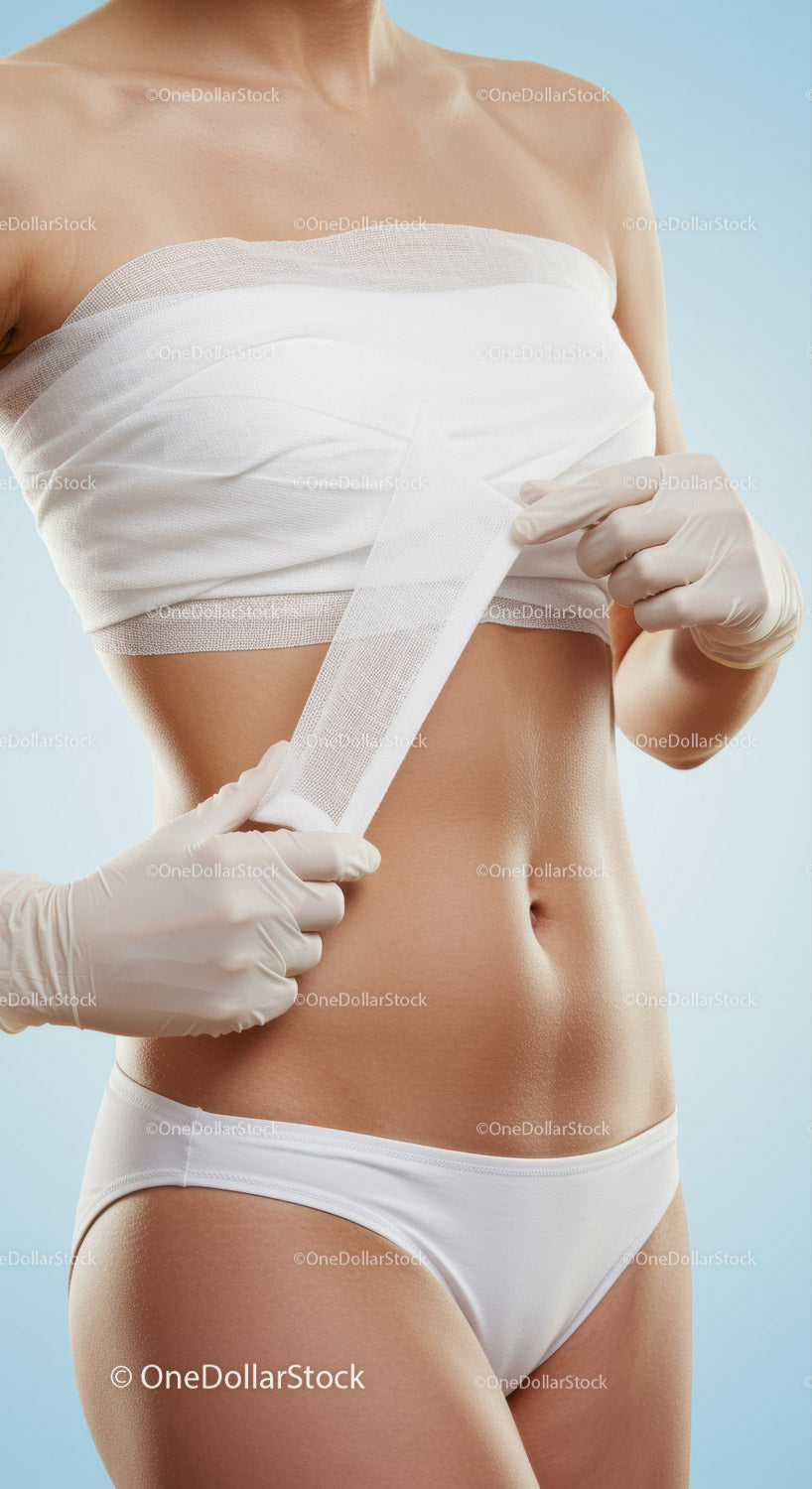Woman Applying Medical Bandage on Abdomen in Healthcare Setting