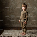 Toddler standing barefoot on textured rug in cozy room