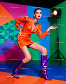 Confident woman striking pose in vibrant orange dress