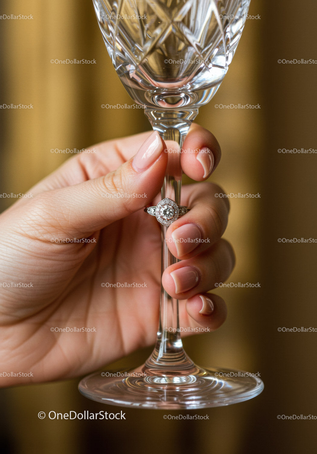 Woman holding crystal glass with elegant diamond ring