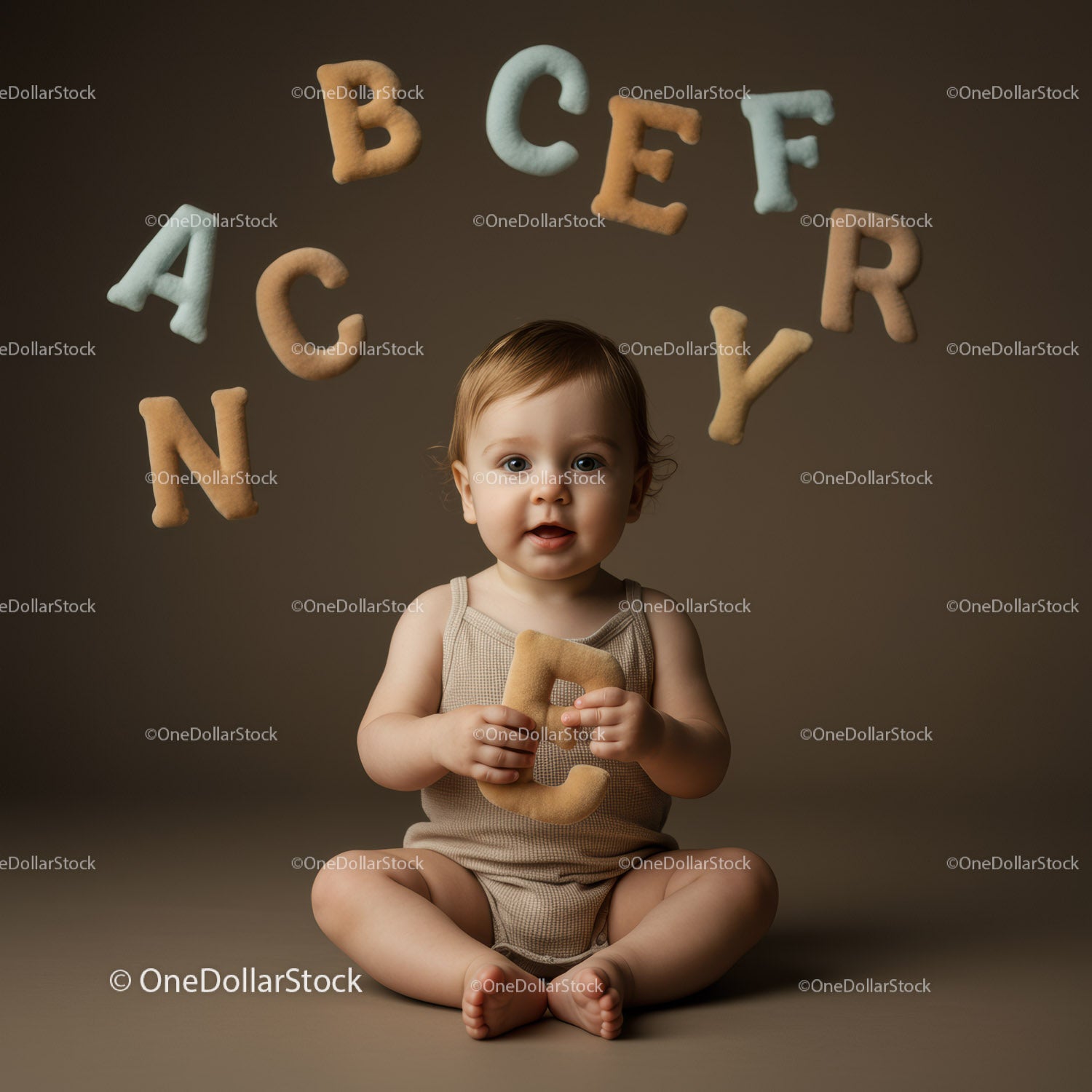 Toddler Sitting with Soft Alphabet Letters on Brown Background