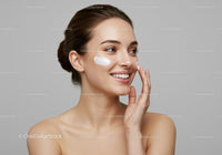 Young Woman Applying Facial Moisturizer for Healthy Glowing Skin