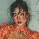 Close-Up of a Woman with Dark Hair and Golden Jewelry in Glamorous Style