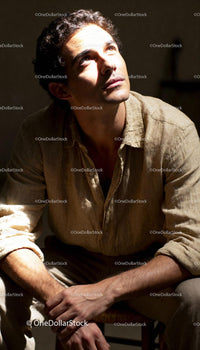 Young man lost in thought under warm sunlight
