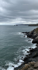 Misty Ocean Coastline with Rocky Cliffs and Stormy Sky